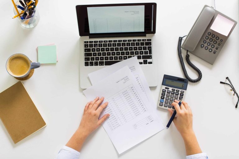 hands with calculator and papers at office table